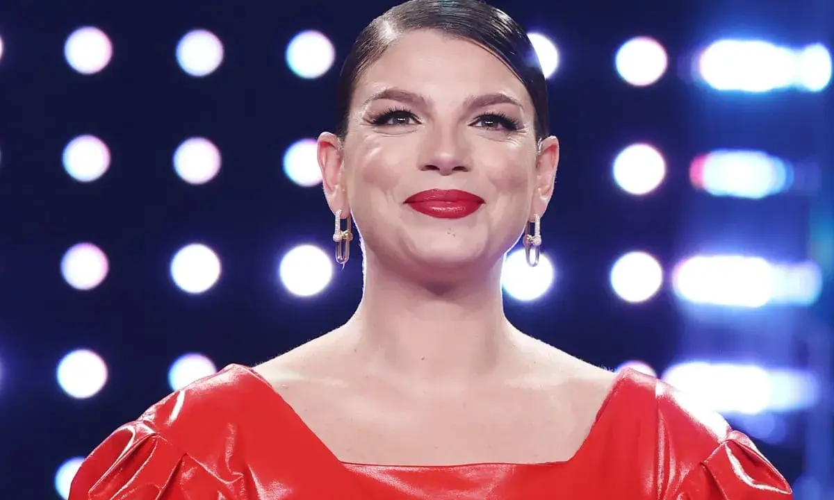 Emma Marrone sorride con un vestito rosso acceso e orecchini luminosi. Chissà se pensa al suo emma marrone fidanzato.