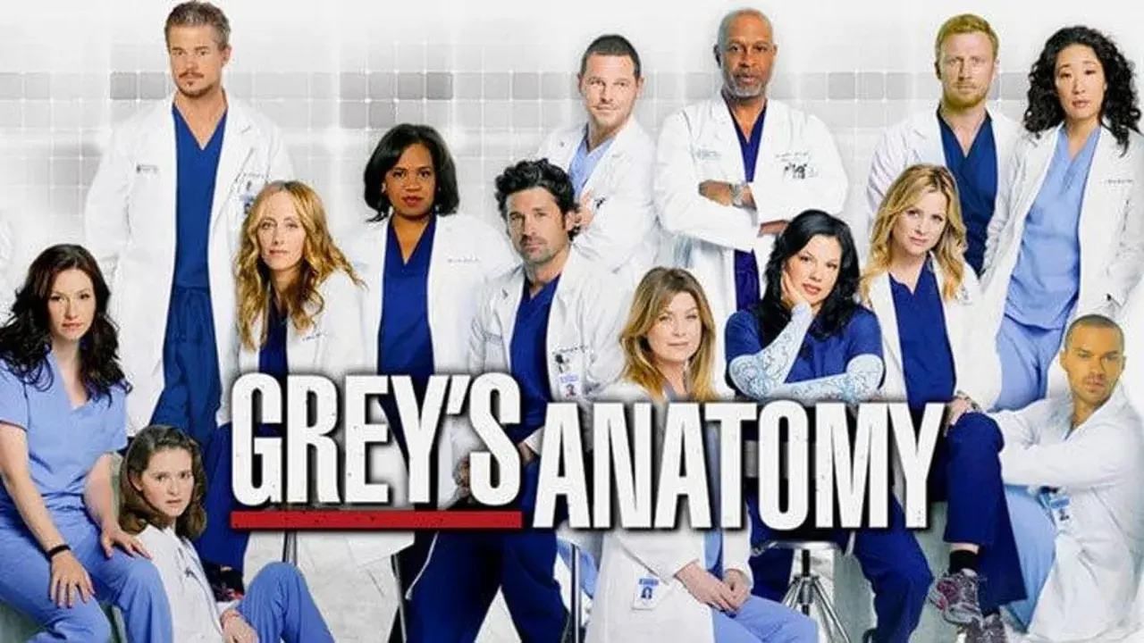 Il cast di Grey's Anatomy 22, con medici in camice bianco e blu, pronto per nuove sfide al Seattle Grace Hospital.