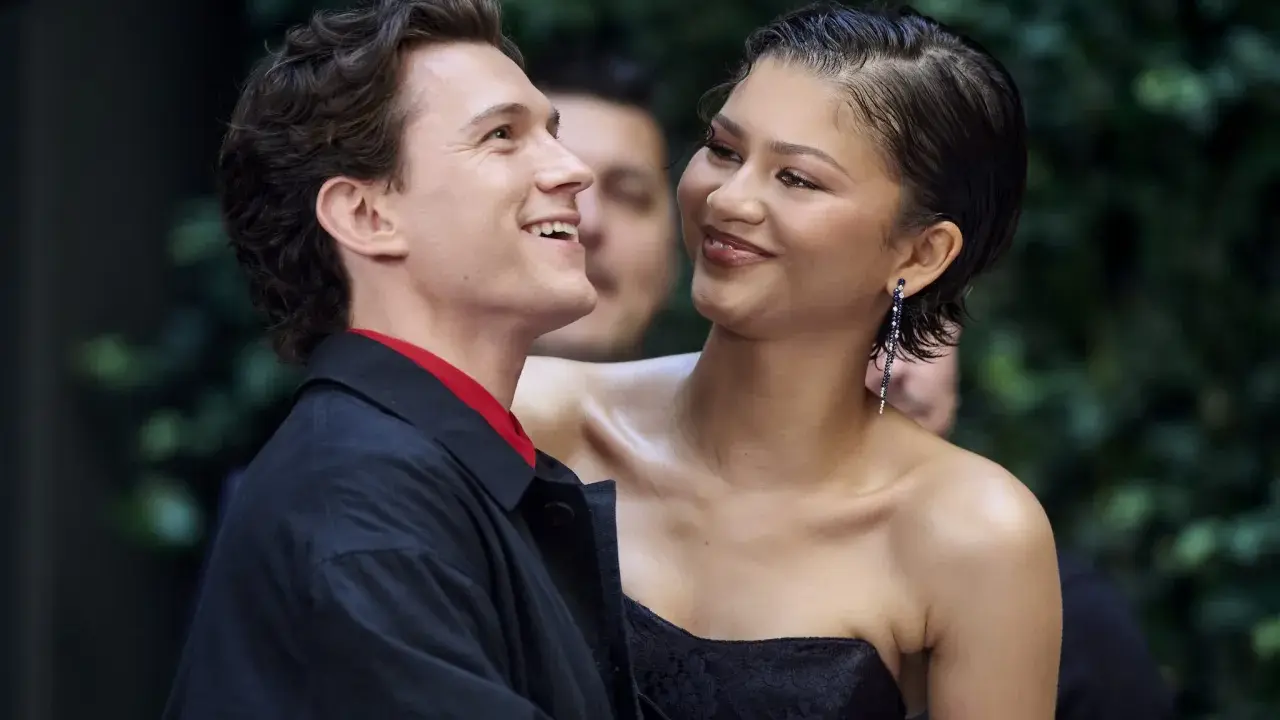 Tom Holland e Zendaya, un momento di complicità sul red carpet. Lei sorride guardandolo, lui ricambia con un sorriso radioso.