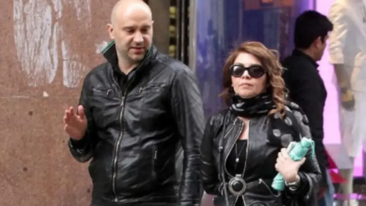 Cristina D'Avena passeggia con quello che sembra essere il suo marito, entrambi vestiti di pelle nera.