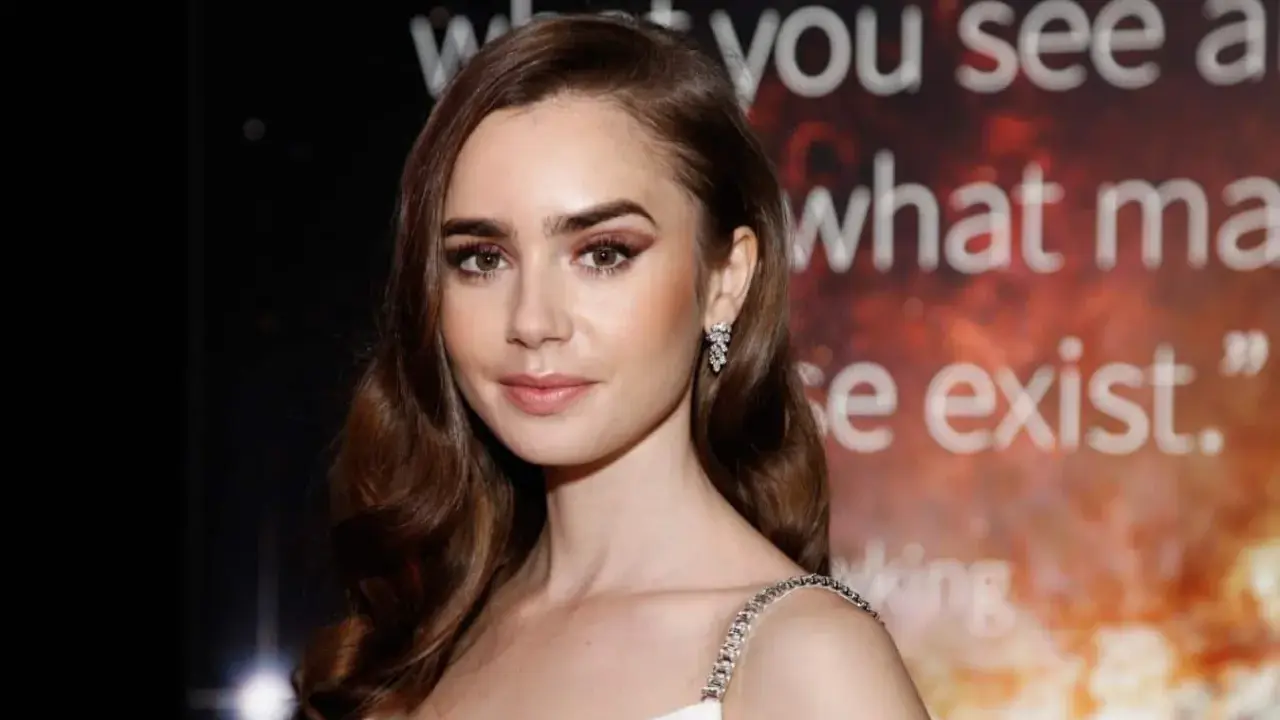 Lily Collins, protagonista di film e programmi TV, con un'espressione pensierosa e un abito scintillante.