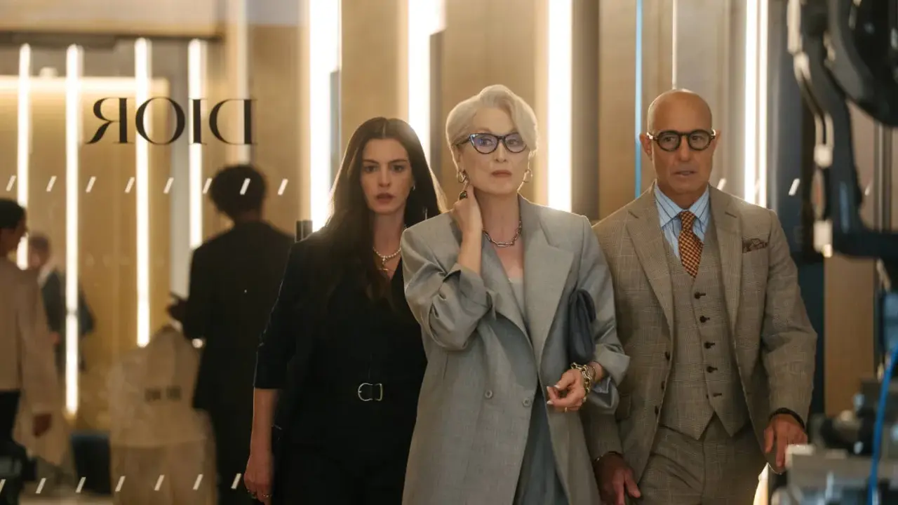 Anne Hathaway, Meryl Streep e Stanley Tucci camminano in un ambiente elegante, forse una boutique di lusso a Milano, ricordando "Il diavolo veste Prada 2".