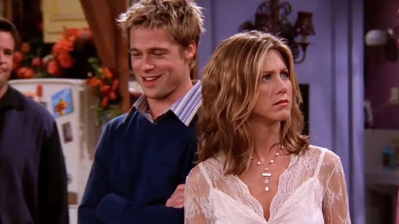 Brad Pitt sorride mentre Jennifer Aniston guarda con espressione preoccupata.