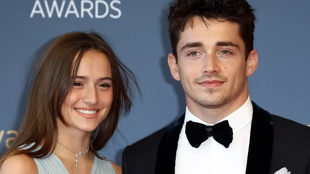 Charles Leclerc e la sua fidanzata sorridono sul red carpet.