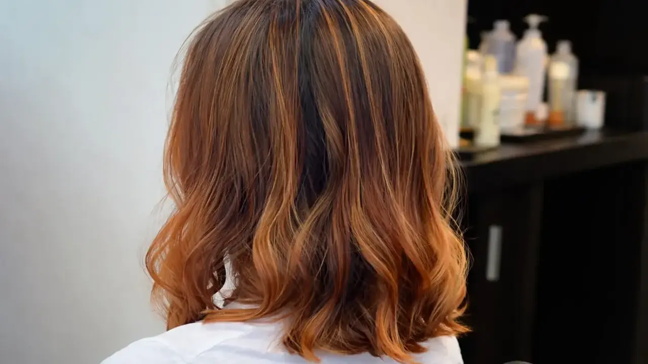 Capelli castani con riflessi ramati, un taglio di capelli un po più lungo del caschetto, leggermente mossi.