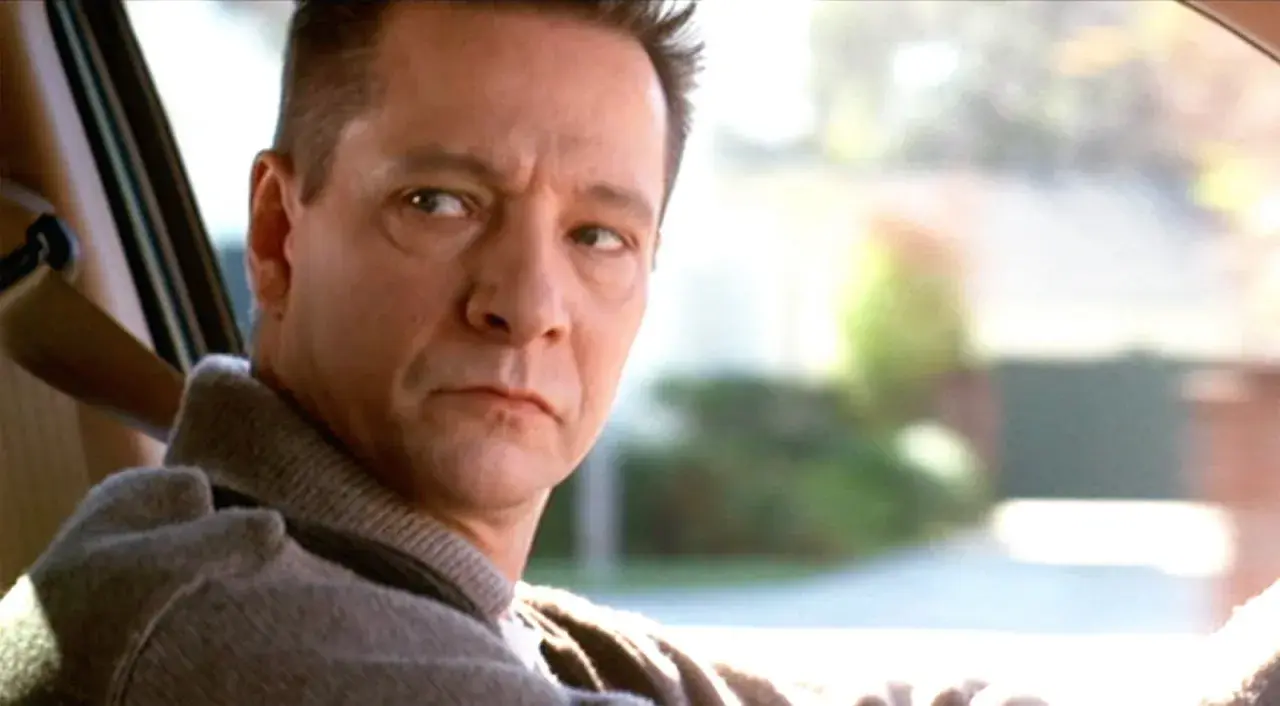 Primo piano di Chris Cooper, uno dei volti del cast di American Beauty, mentre guida.