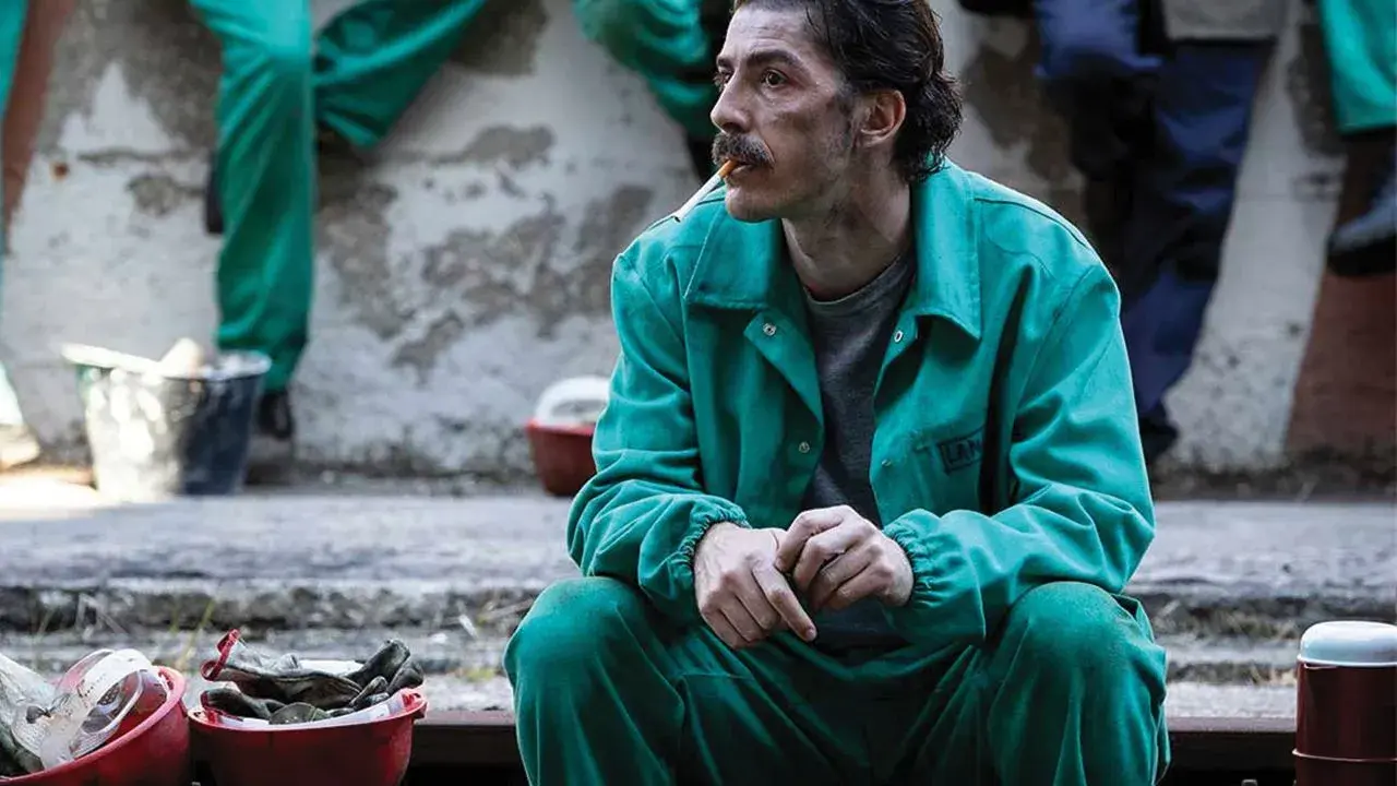Michele Riondino in tuta verde, un'immagine che evoca scene dai suoi film e programmi TV.