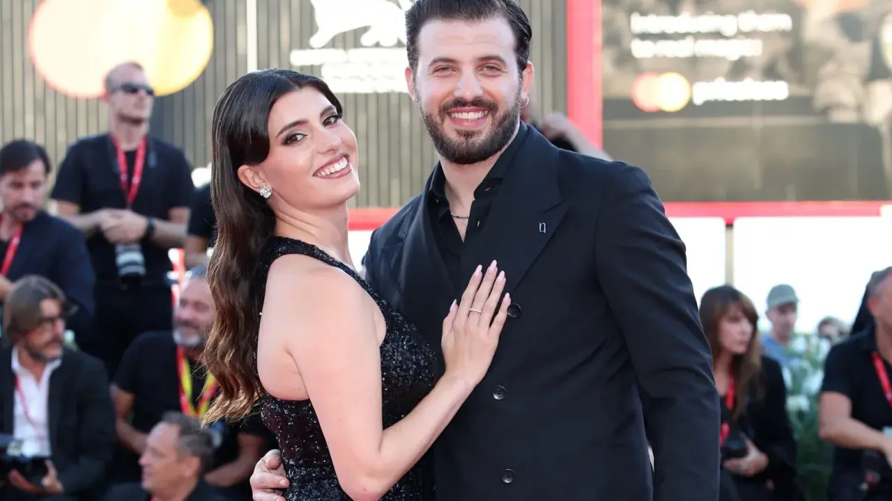 Gaetano Migliaccio e la sua compagna sorridono sul red carpet, un momento di gioia che ricorda la spensieratezza di "Mare Fuori".