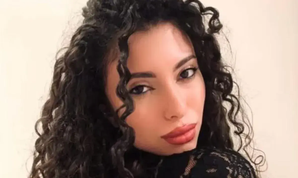 La nuova fidanzata di Raimondo Todaro, con lunghi capelli ricci e labbra rosse, posa con un abito di pizzo nero.