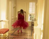 E così, con un vortice di tulle rosso, una donna balla in un corridoio luminoso.