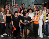 Il cast di Boris posa per una foto di gruppo, con un uomo che tiene una boccia con un pesce rosso.