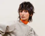 Modella con sbarazzini tagli capelli corti spettinati, ciocche viola e un look audace.