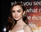 Lily Collins, protagonista di film e programmi TV, con un'espressione pensierosa e un abito scintillante.
