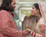 Anant Ambani matrimonio: la sposa sorride guardando lo sposo, entrambi vestiti con abiti tradizionali riccamente decorati.