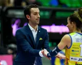 Santarelli de Gennaro, allenatore, stringe la mano a una giocatrice di pallavolo con la maglia numero 10.