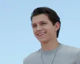 Tom Holland sorride con un maglione grigio. Chissà quanti anni ha Tom Holland?