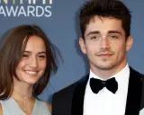 Charles Leclerc e la sua fidanzata sorridono sul red carpet.