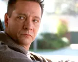 Primo piano di Chris Cooper, uno dei volti del cast di American Beauty, mentre guida.