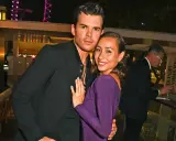 Luke Newton e la sua fidanzata, sorridenti e abbracciati, in un evento serale.