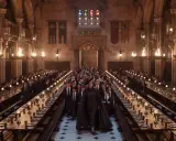 La Grande Sala di Hogwarts, con studenti in divisa e torce accese, pronta per una nuova avventura della **harry potter serie tv**.