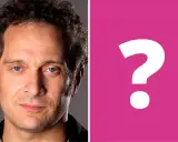 Primo piano di Claudio Santamaria, con un punto interrogativo rosa a destra. Forse si cerca la sua ex moglie?