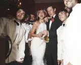 Dua Lipa festeggia il suo matrimonio con amici in abiti eleganti, champagne alla mano.