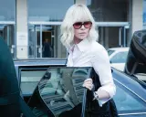 Annalisa, la protagonista di Atomic Blonde, scende da un'auto con un look audace e un'aria determinata.