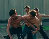 Ragazzi a torso nudo si allenano in un cortile, un momento intenso dalla **prisma serie tv**.