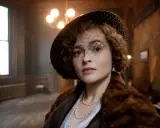 Helena Bonham Carter, con cappello e velo, indossa una pelliccia e perle. Scena da un film.