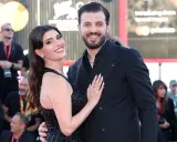 Gaetano Migliaccio e la sua compagna sorridono sul red carpet, un momento di gioia che ricorda la spensieratezza di "Mare Fuori".