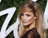 Donna con capelli sciolti eleganti, sguardo intenso e trucco deciso, sullo sfondo di un logo scintillante.