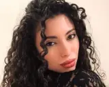 La nuova fidanzata di Raimondo Todaro, con lunghi capelli ricci e labbra rosse, posa con un abito di pizzo nero.