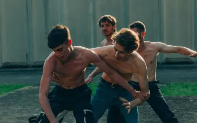 Ragazzi a torso nudo si allenano in un cortile, un momento intenso dalla **prisma serie tv**.