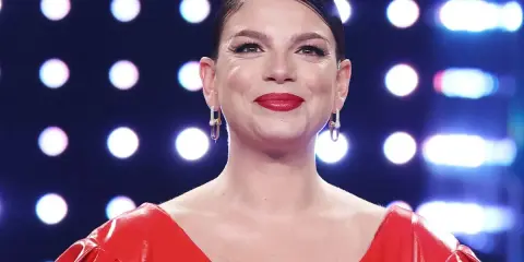 Emma Marrone sorride con un vestito rosso acceso e orecchini luminosi. Chissà se pensa al suo emma marrone fidanzato.