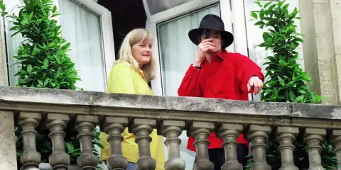 Michael Jackson con un cappello nero e una camicia rossa, accanto a una donna bionda. Forse la sua moglie?