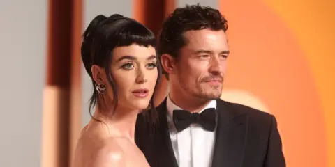 Katy Perry e Orlando Bloom, una coppia iconica, posano elegantemente.