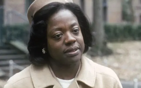 Viola Davis, con un cappello e un cappotto beige, in una scena di film e programmi TV.