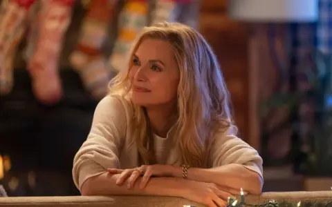 Michelle Pfeiffer in un film natalizio, con calze appese al camino e luci scintillanti.