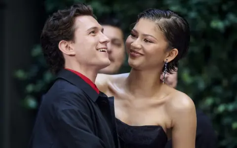 Tom Holland e Zendaya, un momento di complicità sul red carpet. Lei sorride guardandolo, lui ricambia con un sorriso radioso.