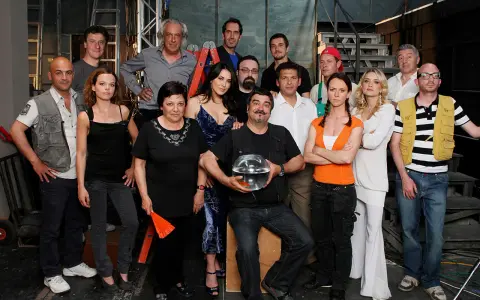 Il cast di Boris posa per una foto di gruppo, con un uomo che tiene una boccia con un pesce rosso.