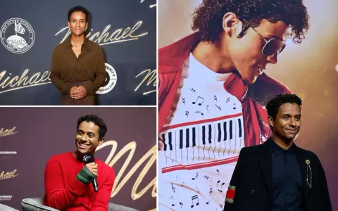 Jaafar Jackson, che interpreta Michael Jackson nel film, sorride con un completo nero e una giacca con dettagli dorati.