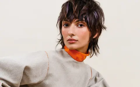 Modella con sbarazzini tagli capelli corti spettinati, ciocche viola e un look audace.