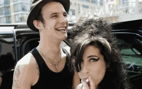 Blake Fielder-Civil oggi, con un sorriso e un cappello, accanto ad Amy Winehouse che fuma.