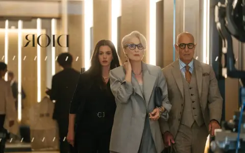 Anne Hathaway, Meryl Streep e Stanley Tucci camminano in un ambiente elegante, forse una boutique di lusso a Milano, ricordando "Il diavolo veste Prada 2".