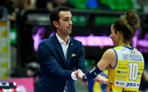 Santarelli de Gennaro, allenatore, stringe la mano a una giocatrice di pallavolo con la maglia numero 10.
