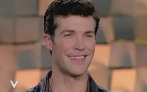 Roberto Bolle smiles, looking to the side.