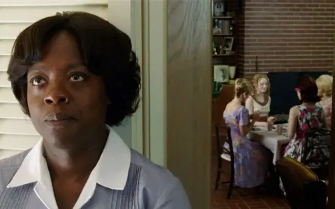 Viola Davis, nel cast di The Help, osserva un gruppo di donne riunite a tavola.