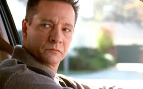 Primo piano di Chris Cooper, uno dei volti del cast di American Beauty, mentre guida.