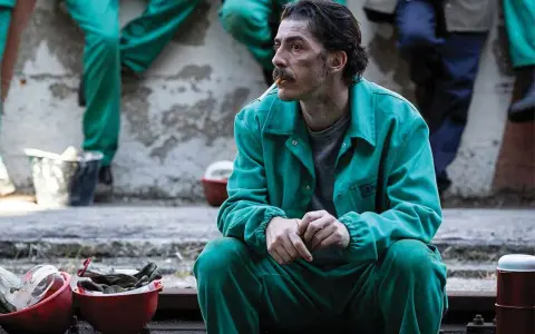 Michele Riondino in tuta verde, un'immagine che evoca scene dai suoi film e programmi TV.