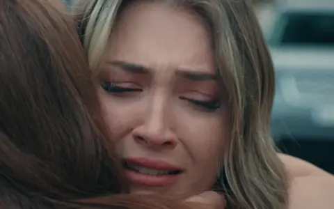 Una ragazza piange disperata, abbracciata da un'altra persona. Una scena toccante dalla **innocence serie turca**.